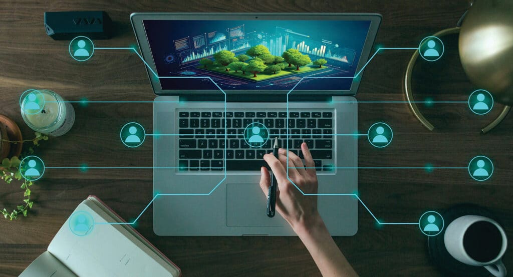 A person's hand holding a pen on a laptop with trees on the screen.