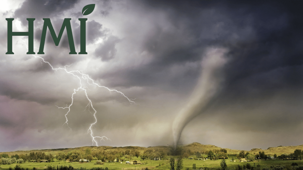 A photo of a tornado and lightning over a landscape dotted with buildings. HMI's logo is in the upper left corner.