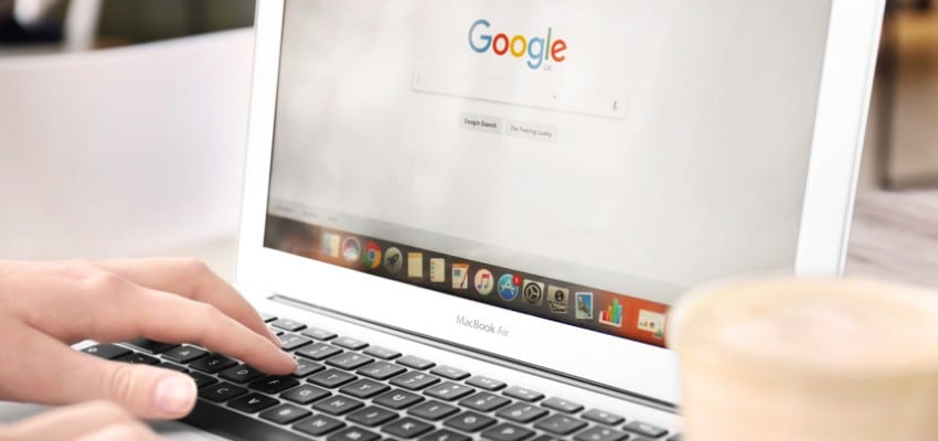 A couple of hands with a laptop, searching on google.